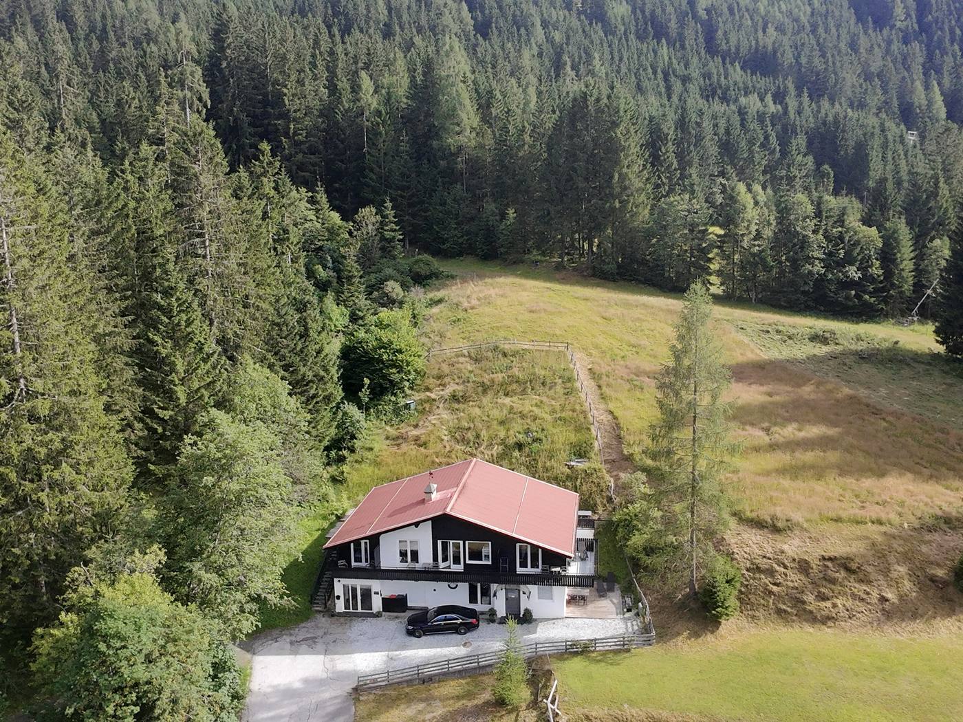 Die Waldvilla im Sommer, umgeben von Wald und Wiesen