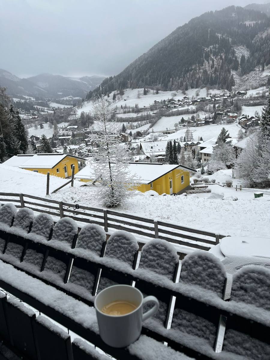 Kaffee auf dem Balkon mit Blick auf das verschneite Dorf